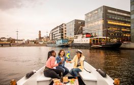 Young female friends having picnic on boat tour