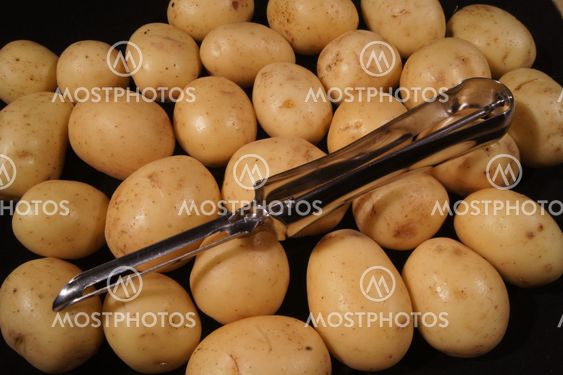 Potatoes with peeler.