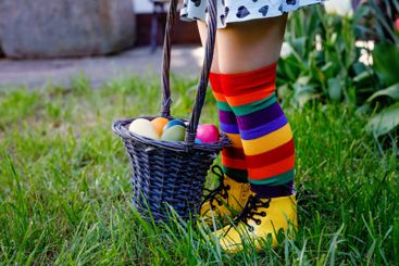 Close-up of legs of toddler girl with colorful stockings...