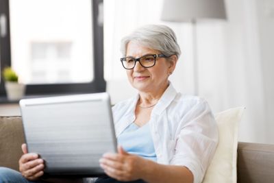 happy senior woman with on laptop computer at home