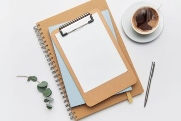 Clipboard, coffee, pen and notebook creating home office...