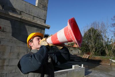 Man shouting through traffic cone