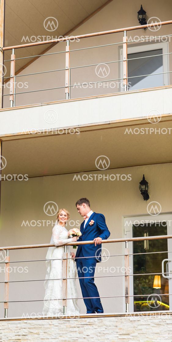 the bride and groom on a balcony