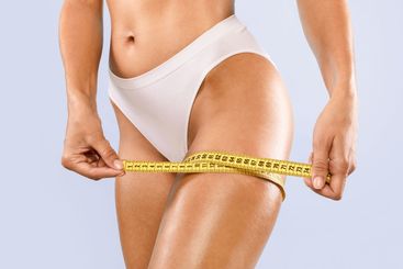 Closeup of Unrecognizable Lady Measuring Thigh With...