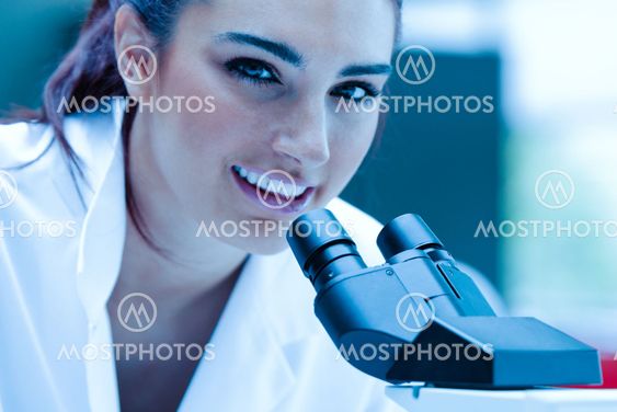 Young scientist posing with a microscope