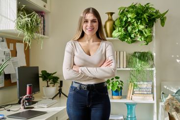 Portrait of young confident smiling woman in home interior