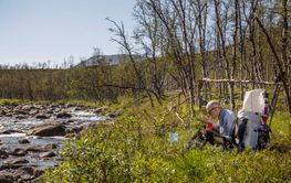 Man sitting by river while camping