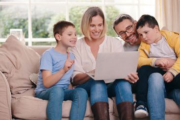 Happy, laptop and parents with children on sofa for...