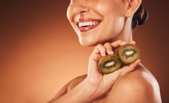 Beauty, skincare and kiwi with a model woman in studio...