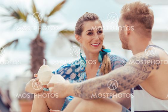 Young couple holding coconut water