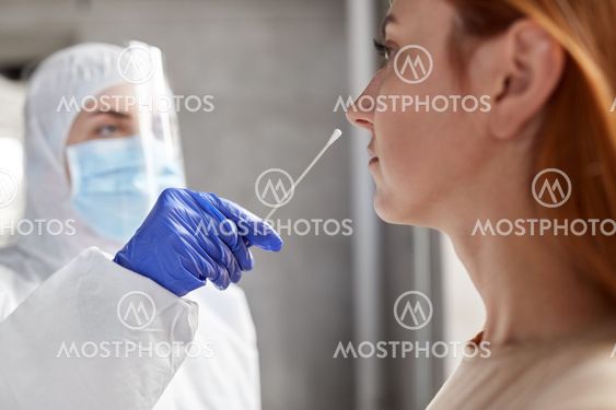 doctor in protective wear making coronavirus test