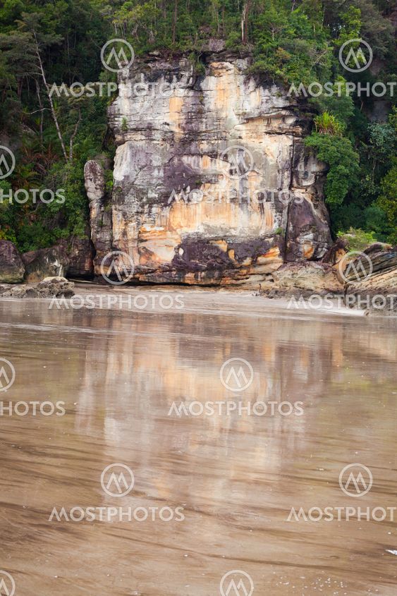 Big rock reflection from wet sand