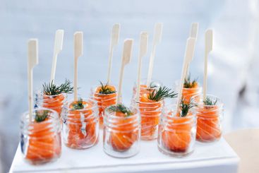 Small glass jars with pieces of red salted fish and...