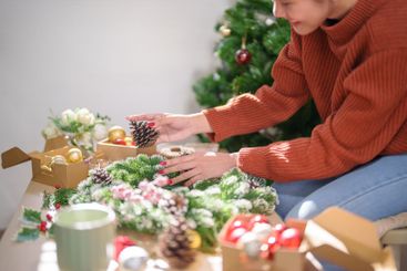 Woman making mistletoe wreath Christmas wreath...