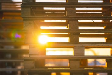 stacked wooden pallets with sunlight streaming through.