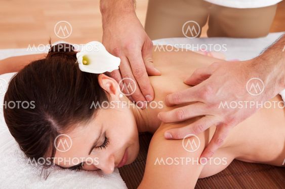 Beautiful young woman getting shoulder massage