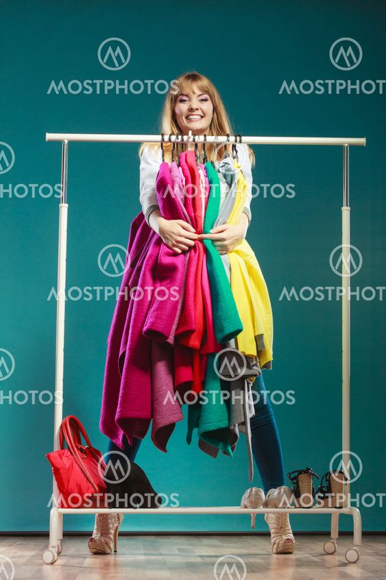 Funny woman taking all clothes in mall or wardrobe