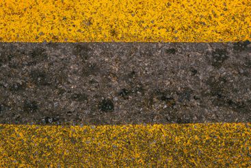 Yellow paint road marking on asphalt highway surface,...
