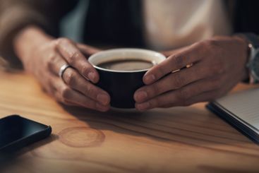 Hands, coffee and man at desk, relax and professional...