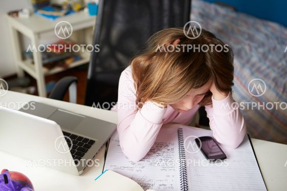 Girl Using Mobile Phone Instead Of Studying In Bedroom