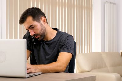 Young man talking on the phone while he's at the office