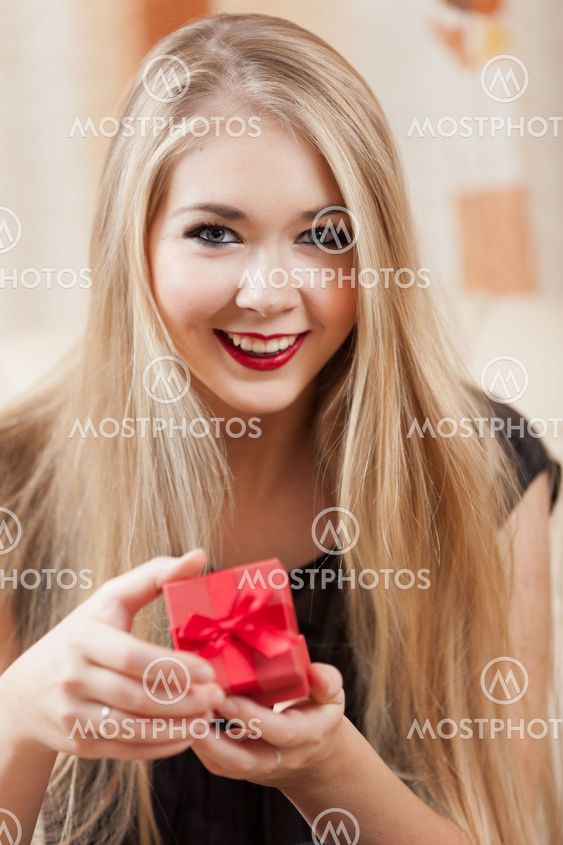 Beautiful young blond holding red gift box.