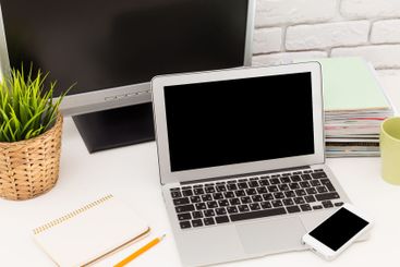 Workspace setup featuring laptop, monitor, and...