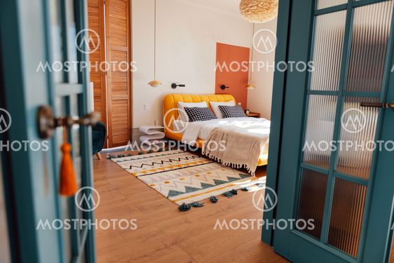 A cozy bedroom with white walls. An open stylish blue...