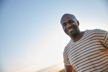 Blue sky, portrait and smile of black man outdoor on...