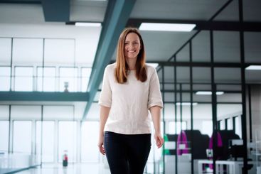 Smiling businesswoman walking to office as marketing...