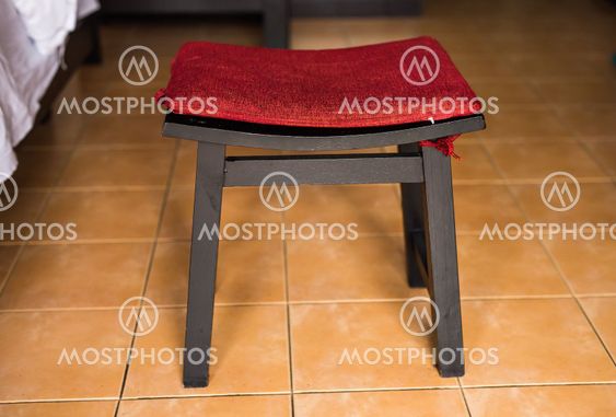modern brown chair with a red pillow