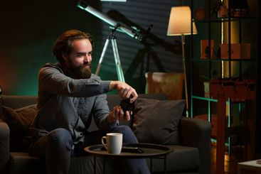 Energic gamer jumping on couch, excited to start videogame
