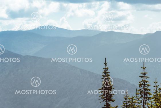 Scenic view of misty mountain valley. Gentle hills under...