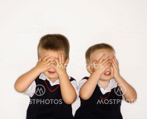 Male twins with hands over eyes.