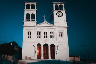White church in Plaka village on Milos island in dusk
