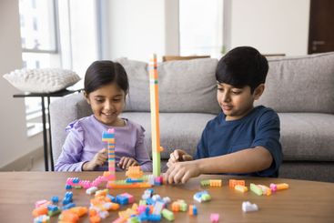 Indian brother and sister play together colorful plastic...