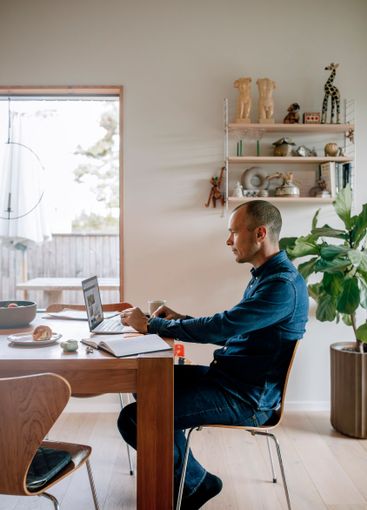 Side view of businessman working on laptop while sitting...