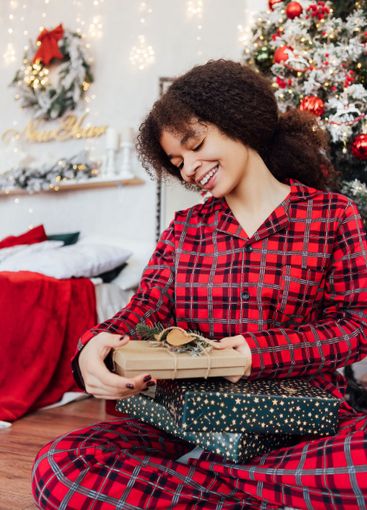 Young smiling African woman is sitting on floor and...