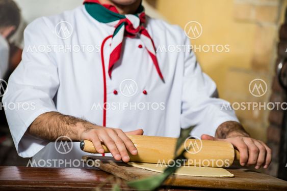 Cook rolls out the dough on a board