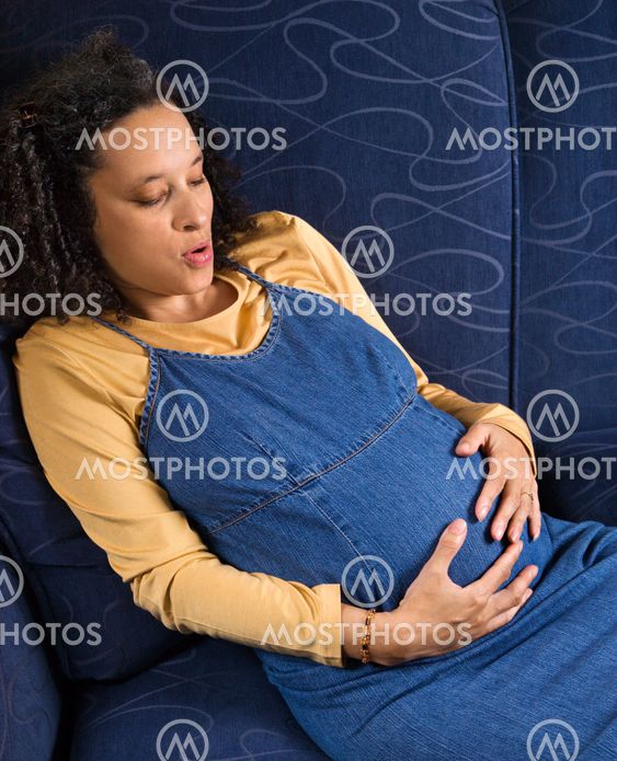 Pregnant woman holding stomach.