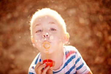 Bubbles, portrait and child in park with fun, sunset...
