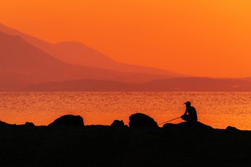 Fishing at the Aegean sea coast in summer sunrise,...