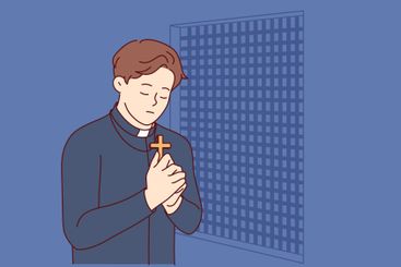 Padre prays and holds christian cross in hands, standing...