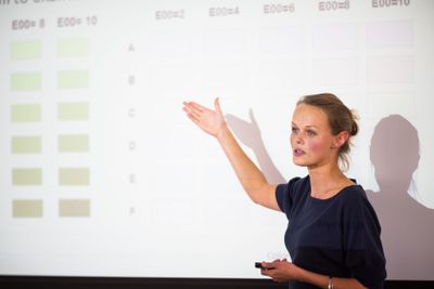 Pretty, young business woman giving a presentation in a...