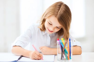 little student girl drawing at school