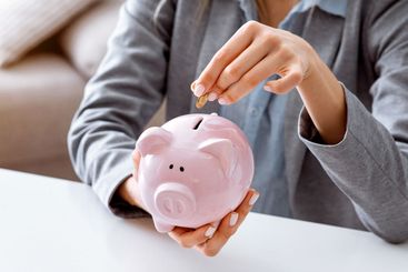 Reduce budget during quarantine. Woman puts coins in...