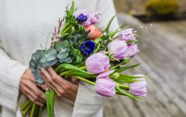 närbild på kvinna som håller bukett med tulpaner