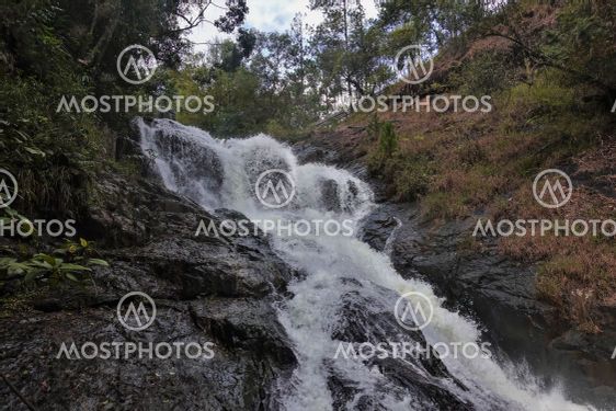 The waterfall cascades down from the rocks.