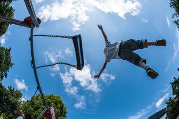 Lindesnes, Norway - July 09 2011: Kid jumping of a swing...