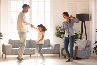 Family dancing in living room spending time on weekend...